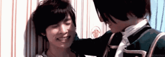 a man is putting his hand on another man 's shoulder .