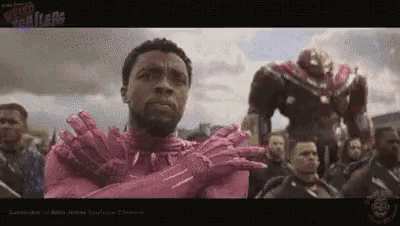 a man in a pink iron man suit is standing in front of a crowd .