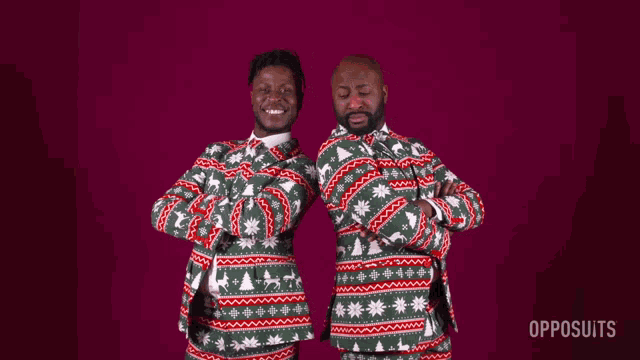 two men wearing ugly christmas sweaters are standing next to each other