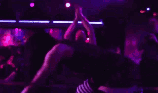a woman is dancing on a stage in a nightclub .