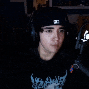 a man wearing headphones and a hat with the letter a on it