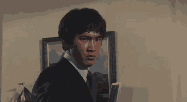 a man in a suit is pointing a gun at something