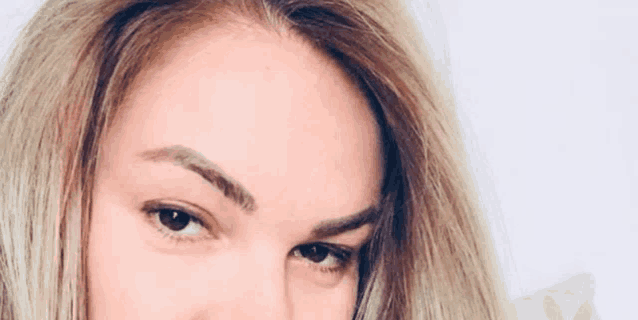 a close up of a woman 's face with a white background