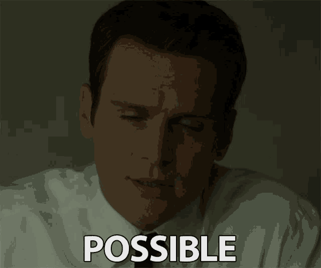 a man in a white shirt and black tie says possible in a dark room