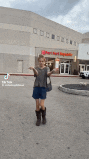 a man wearing shorts and boots is walking in front of a store
