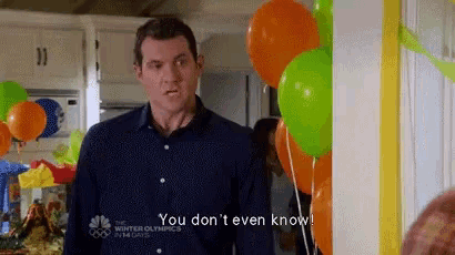 a man is standing in front of a bunch of balloons and says `` you don t even know '' .