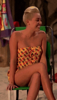 a woman in a bikini sits on a green chair