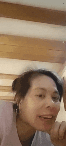 a woman is making a funny face with her hand on her face