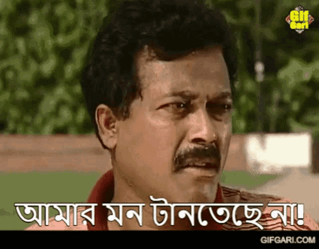 a man with a mustache is making a funny face in a gif .