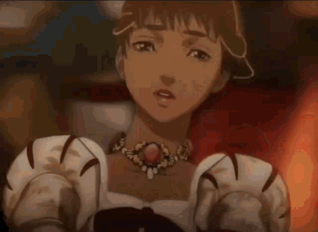 a woman wearing a necklace with a red stone