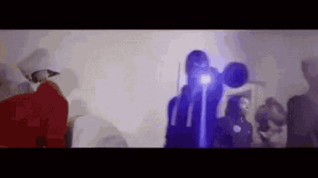 a group of people are standing in a room with a projector .