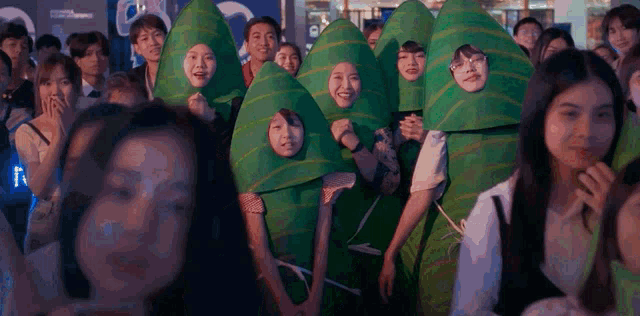 a group of people dressed in green leaves with their faces visible