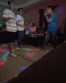 a group of people are dancing in a room with a lot of lights