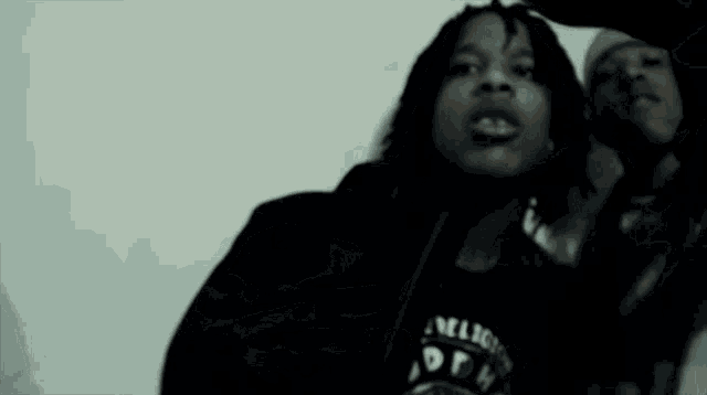 a person wearing a black shirt that says ' nmligion ' on it