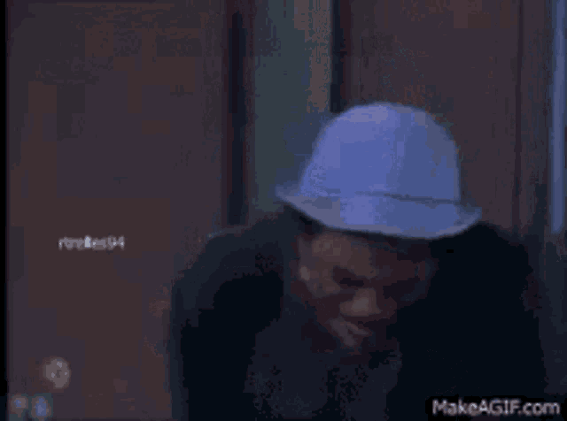 a man wearing a blue hat is standing in front of a door .