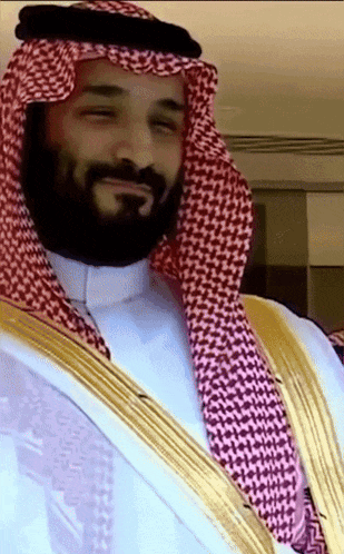 a man with a beard wearing a white shirt and a gold robe