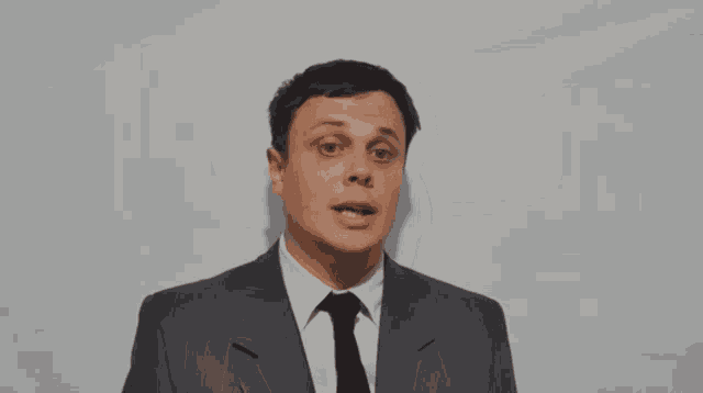 a man in a suit and tie is making a face