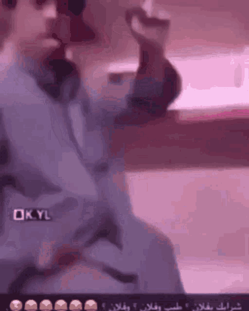 a man is sitting in a chair talking on a phone .