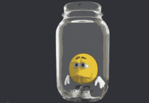 a yellow smiley face is in a clear jar