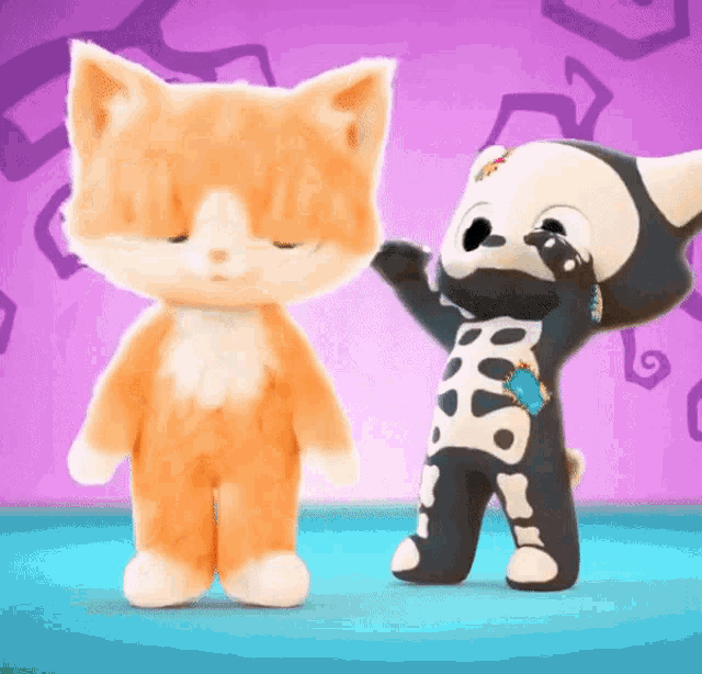 two stuffed animals are standing next to each other one is a cat and the other is a dog