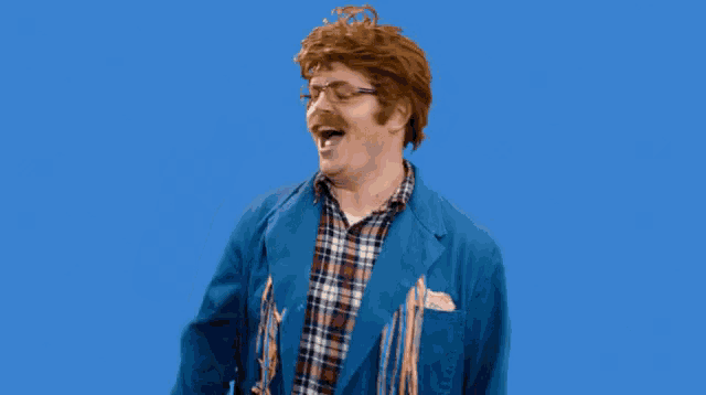 a man wearing a blue jacket and plaid shirt is waving