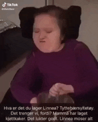 a little girl in a purple sweater is making a funny face .