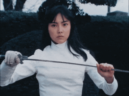 a woman in a white shirt is holding a sword in her right hand