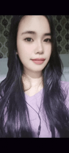 a woman with long purple hair is wearing a purple shirt