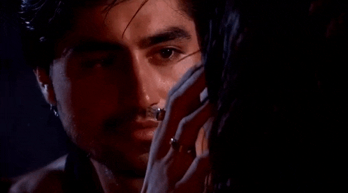 a man and a woman are touching each other 's faces in the dark .