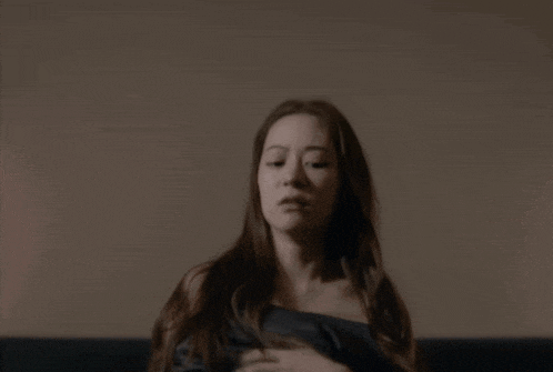 a woman sitting on a couch with the words oh no on the bottom