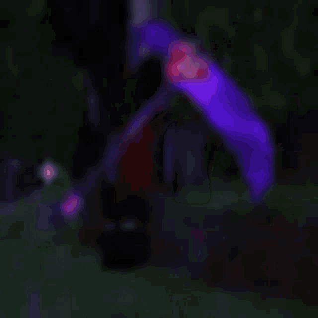 a blurry picture of a person holding a purple sword in a video game .