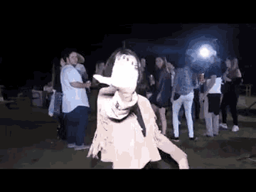 a woman is dancing in front of a crowd at a party .