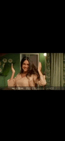a woman is standing in front of a mirror holding her hair in her hands .