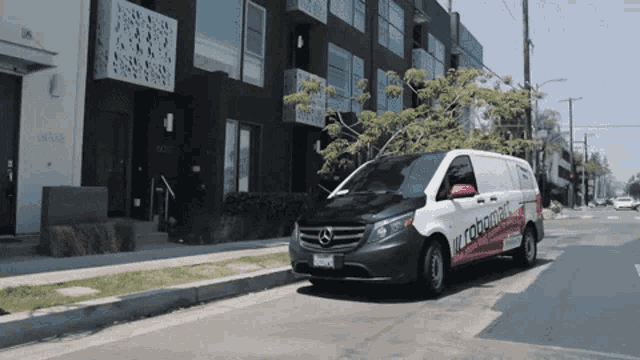 a white van with robomatic written on the side is parked in front of a building