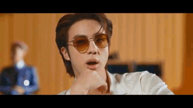a close up of a person wearing sunglasses in a video .
