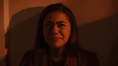 a woman is covering her mouth with her hand in the dark