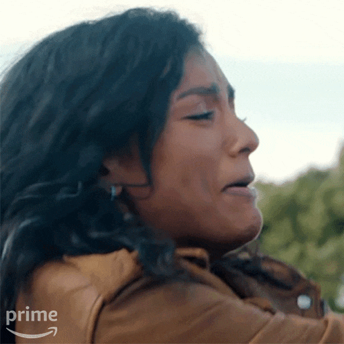 a close up of a woman 's face with a tear coming out of her eye .