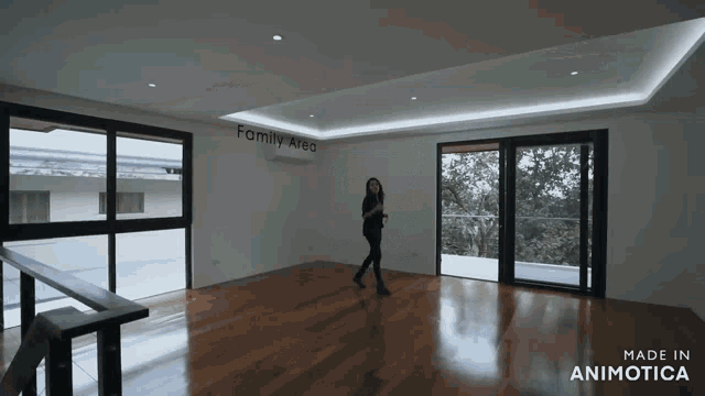 a woman walks through an empty room with the words family area on the wall