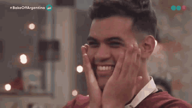 a man is smiling and covering his face with his hands with the words bake off argentina on the bottom right