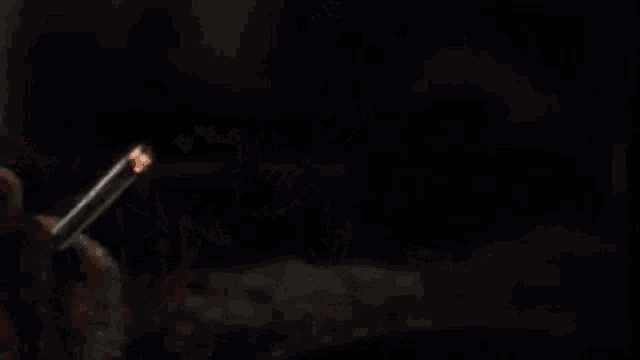 a man is smoking a cigarette in the dark