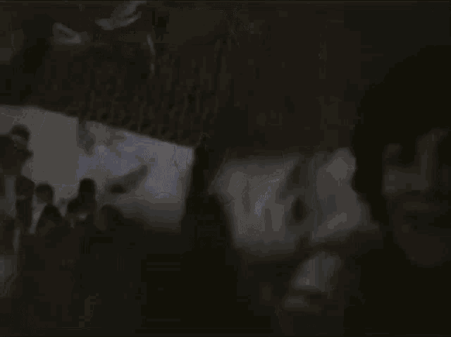 a man and a woman are standing next to each other in the dark .