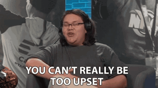 a man wearing headphones is sitting on a couch and saying `` you can 't really be too upset ''