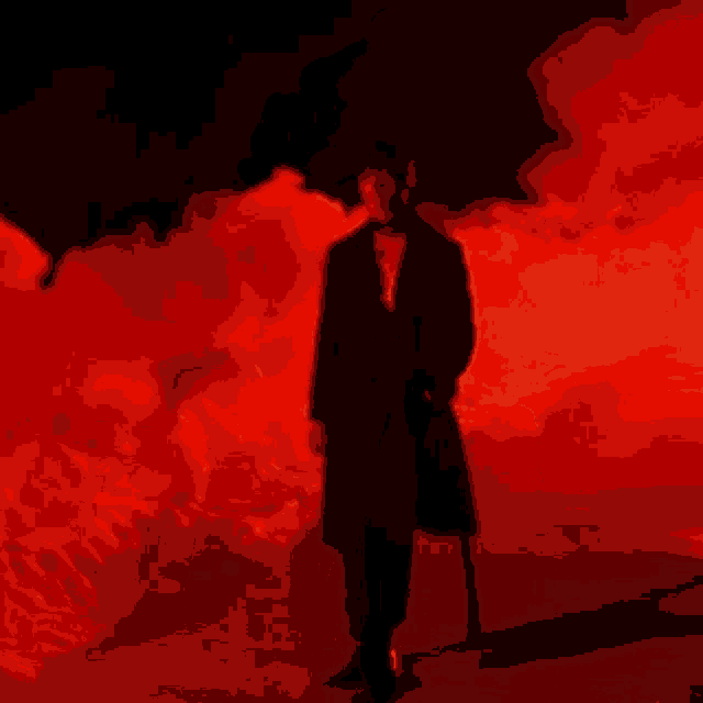 a man in a blue coat is leaning against a wall and looking out the window .