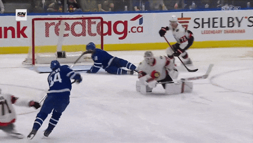 a hockey game is being played in front of an ad for shelby 's legendary shawarma