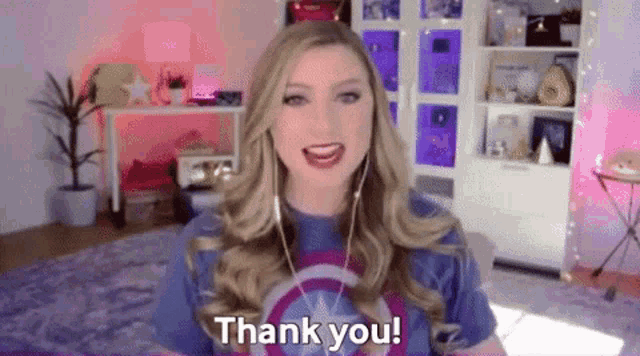 a blonde woman wearing a captain america shirt is saying thank you