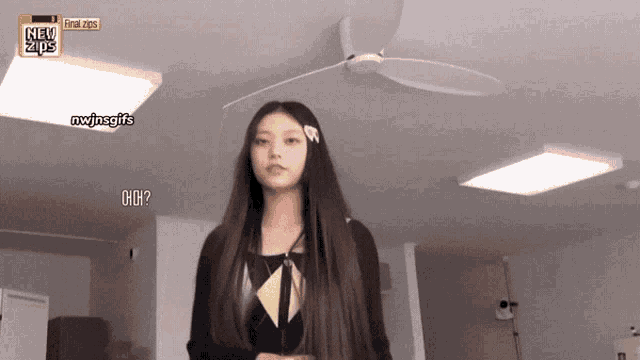 a woman with long hair is standing in front of a ceiling fan and a sign that says new zipper