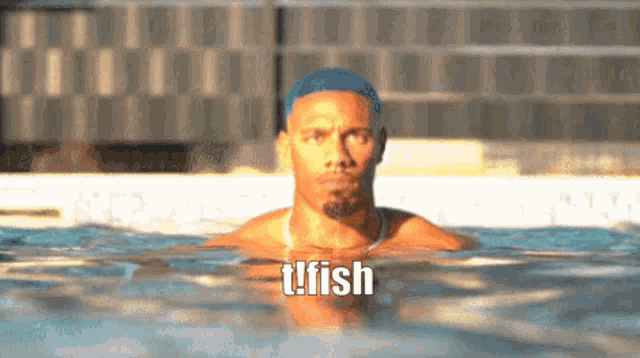 a man is swimming in a pool and the word tfish is on the bottom