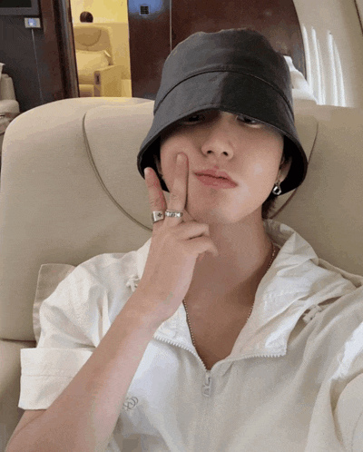 a man wearing a black bucket hat and a white shirt with the letter g on it