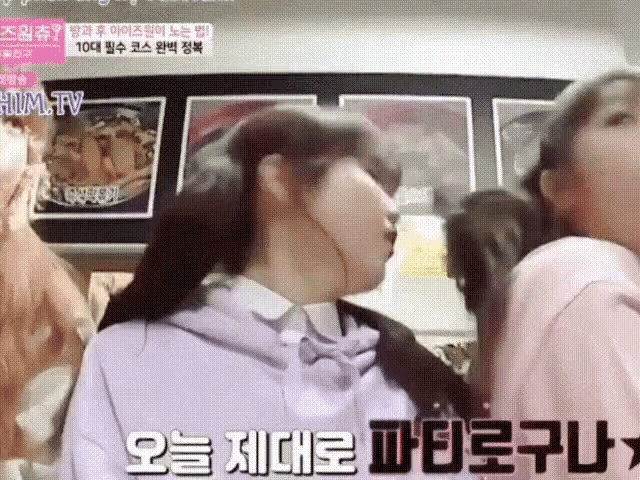 a girl in a purple hoodie is being kissed by another girl