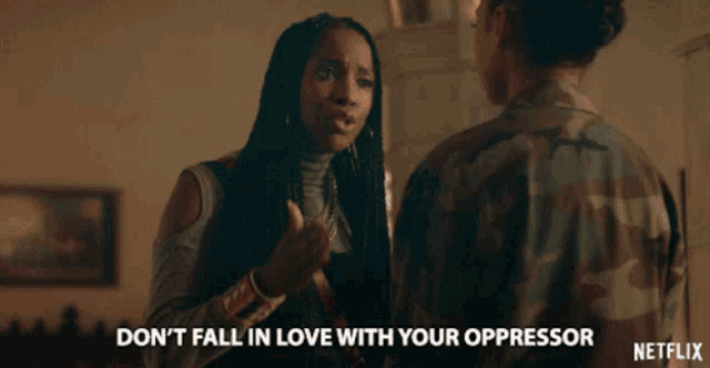 a woman in a camouflage jacket is talking to another woman and says " don t fall in love with your oppressor "